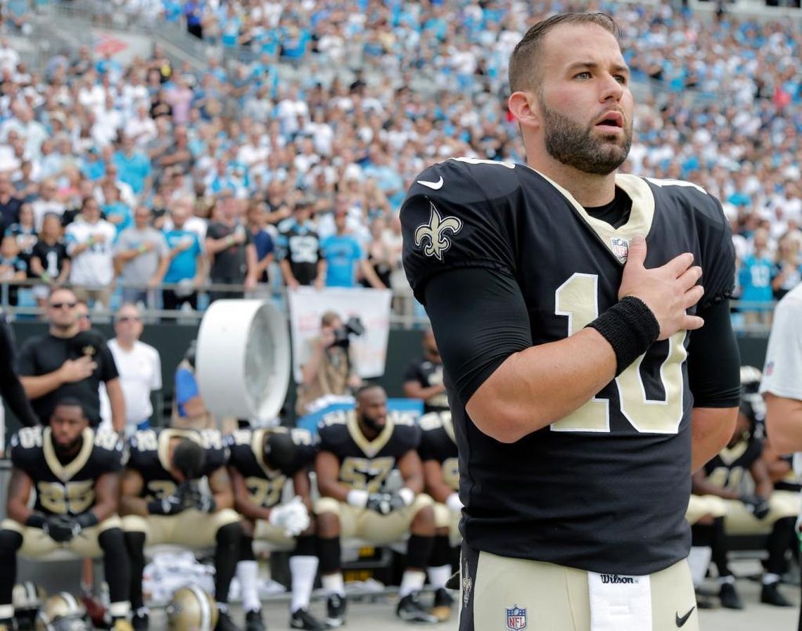 New Orleans quarterback Chase Daniel stands during the national anthem as other Saints players sit on the bench before a 2017 NFL against the Carolina Panthers.