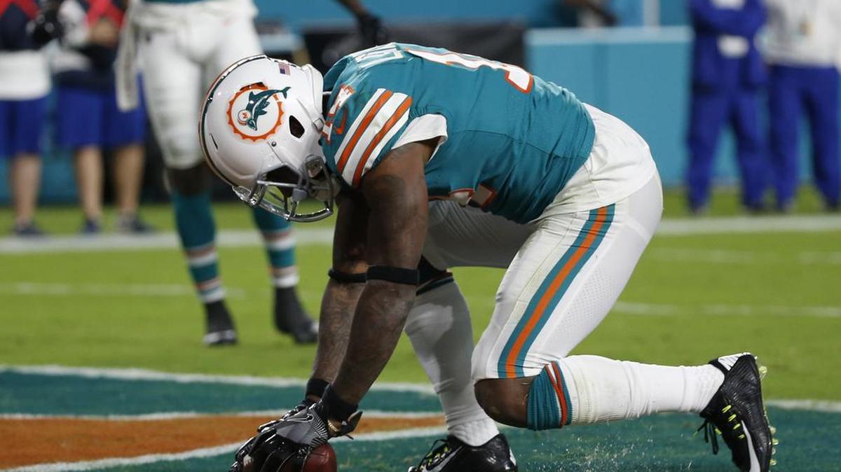 Miami Dolphins wide receiver Jarvis Landry pumps up a deflated football after scoring a touchdown against New England earlier this year.