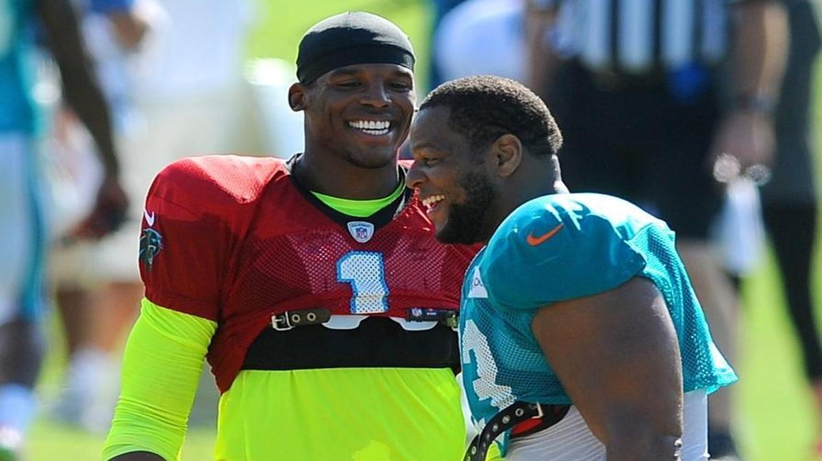 Carolina Panthers quarterback Cam Newton, left, jokes with Miami Dolphins defensive tackle Ndamukong Suh, right, during a joint practice Thursday, August 20, 2015 at Wofford College in Spartanburg, S.C.