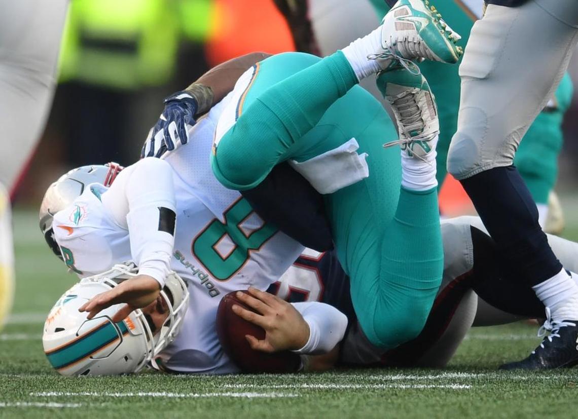 Miami Dolphins quarterback Matt Moore (8) gets sacked by New England Patriots defensive end Trey Flowers (98) in the second quarter on Sun., Nov. 26, 2017 at Gillette Stadium in Foxboro, Mass.