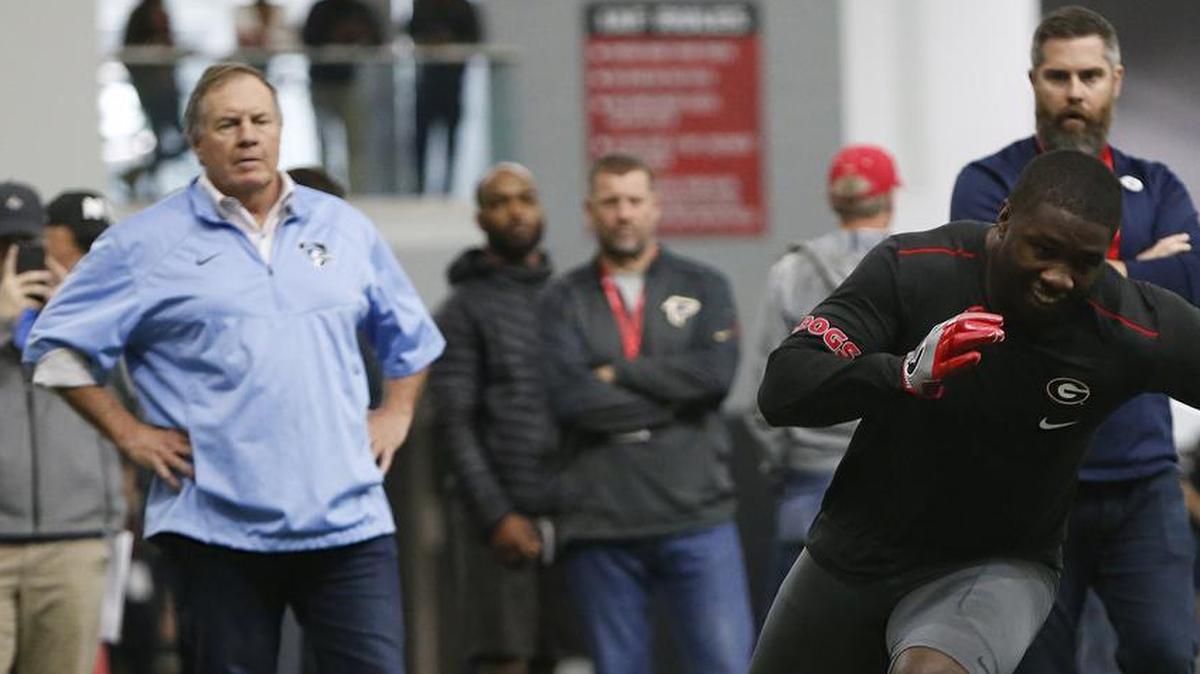 New England Patriots head coach Bill Belichick and Miami Dolphins defensive coordinator Matt Burke watch Georgia linebacker Roquan Smith run a drill during Georgia Pro Day.