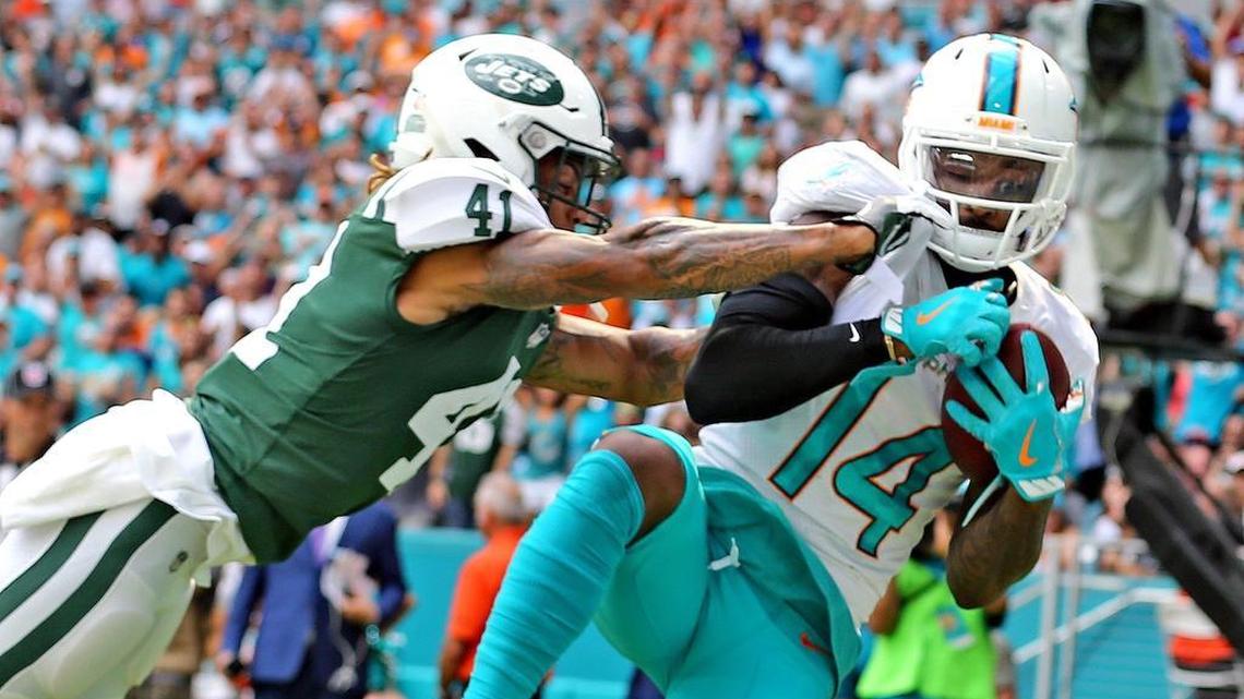 Dolphins receiver Jarvis Landry catches a touchdown pass as Jets Buster Skrine tries to defend.