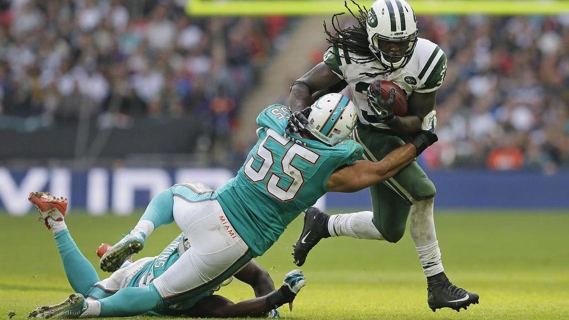 Miami Dolphins' Koa Misi tackles running back Chris Ivory at Wembley Stadium in 2015. (AP Photo/Tim Ireland)