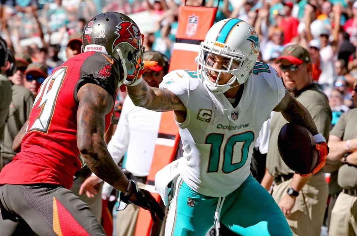 Miami Dolphins Kenny Stills (10) stiff arms Tampa Bay Buccaneers Ryan Smith (29) in the second quarter at Hard Rock Stadium in Miami Gardens, Fla., Nov. 19, 2017.
