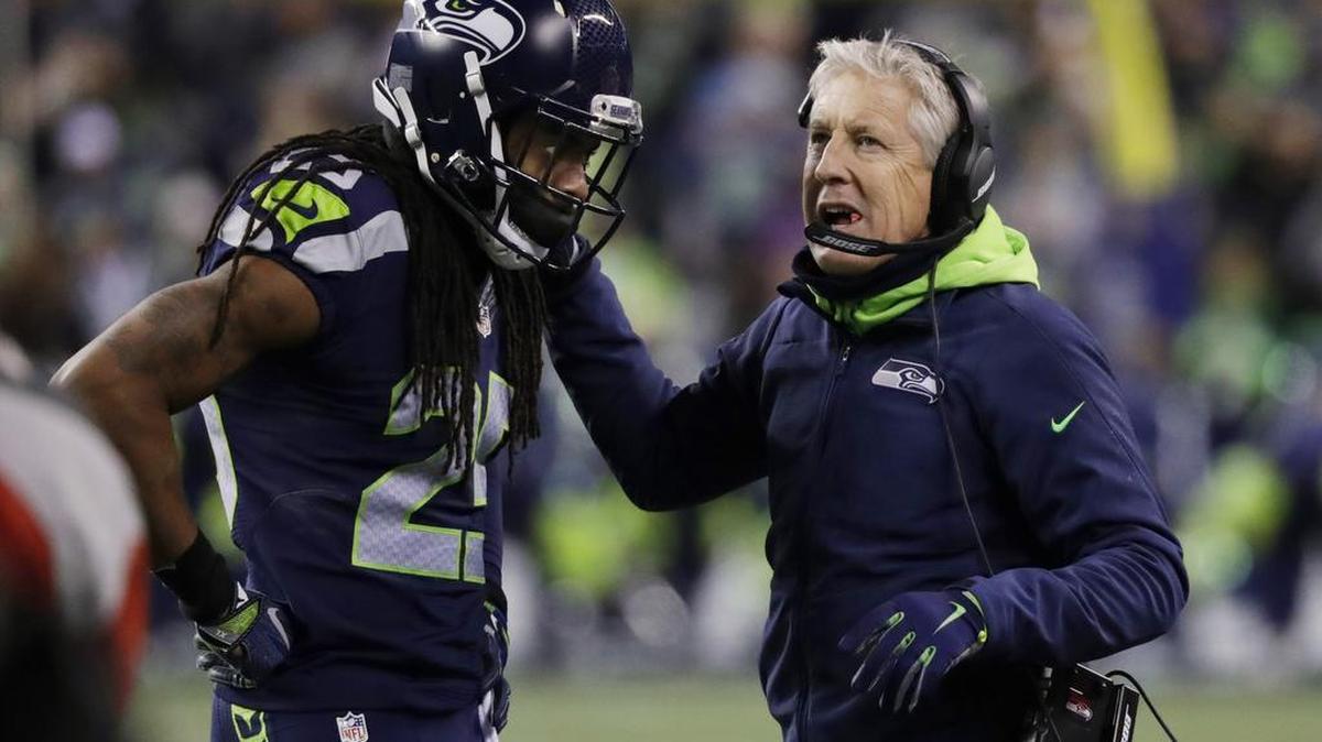 Seattle Seahawks head coach Pete Carroll talks with cornerback Richard Sherman during an NFC wild card playoff game against the Detroit Lions.