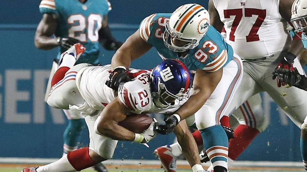 Miami Dolphins defensive tackle Ndamukong Suh (93) sacks New York Giants running back Rashad Jennings (23) in the first quarter. Miami Dolphins host the New York Giants at Sun Life Stadium on Monday, December 14, 2015.
