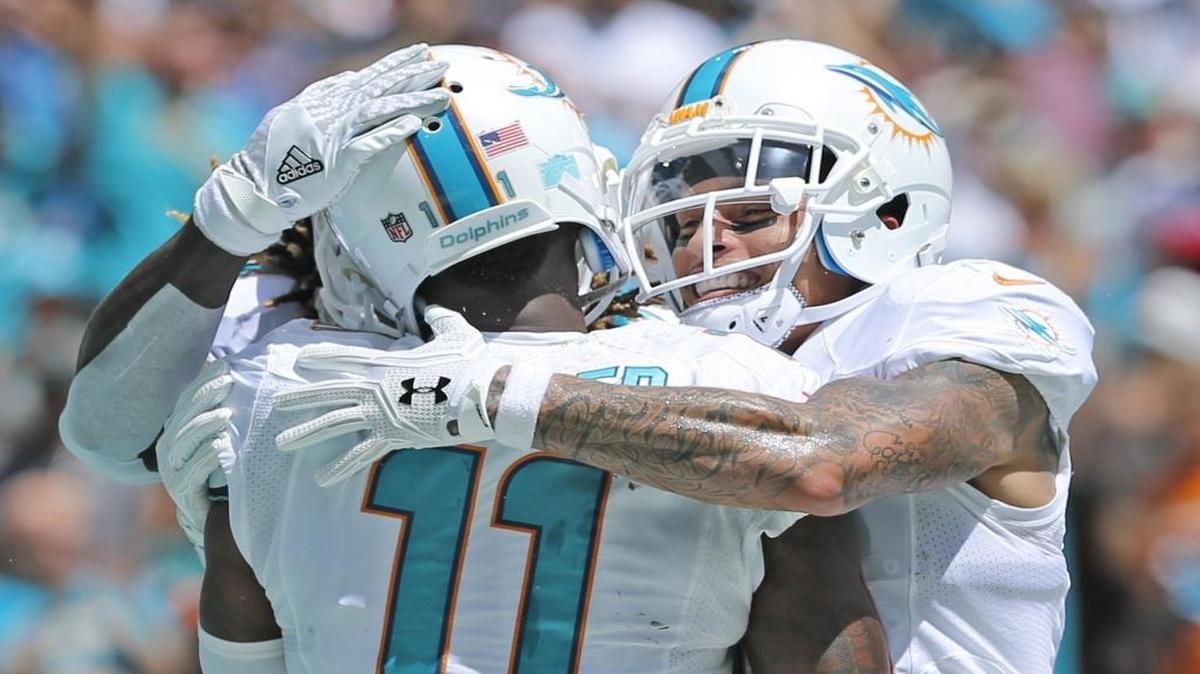 Miami Dolphins wide receiver Kenny Stills (10) and fellow teammates hug Miami Dolphins wide receiver DeVante Parker (11) after scoring in the first quarter as the Miami Dolphins host the Cleveland Browns in the home opener at refurbished Hard Rock Stadium on Sun., Sept. 25, 2016.
