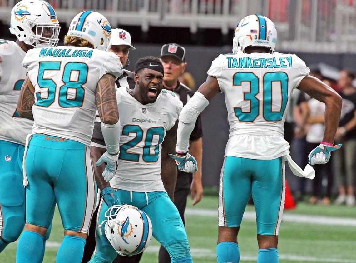 Miami Dolphins Cordrea Tankersley (30) and Reshad Jones (20) celebrate at the end of the fourth quarter on the field after Jones interception to defeat the Atlanta Falcons at the Mercedes-Benz Stadium in Atlanta, Georgia, Oct. 15, 2017.