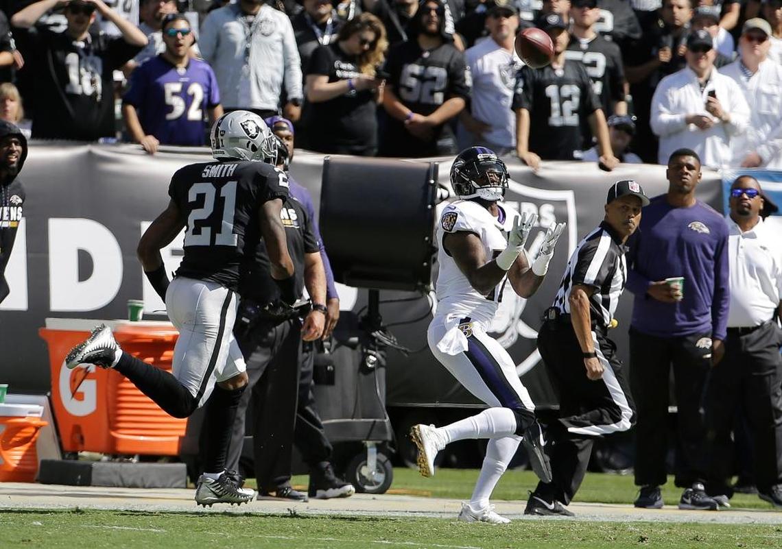 Baltimore Ravens wide receiver Mike Wallace, right, catches a pass in front of Oakland Raiders cornerback Sean Smith (21) during the first half of an NFL football game in Oakland, Calif., Sun., Oct. 8, 2017.