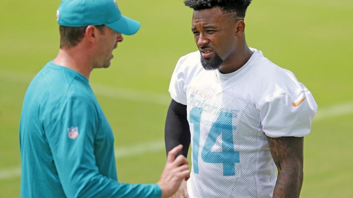 Head coach Adam Gase talks with wide receiver Jarvis Landry during Dolphins minicamp on Wednesday.