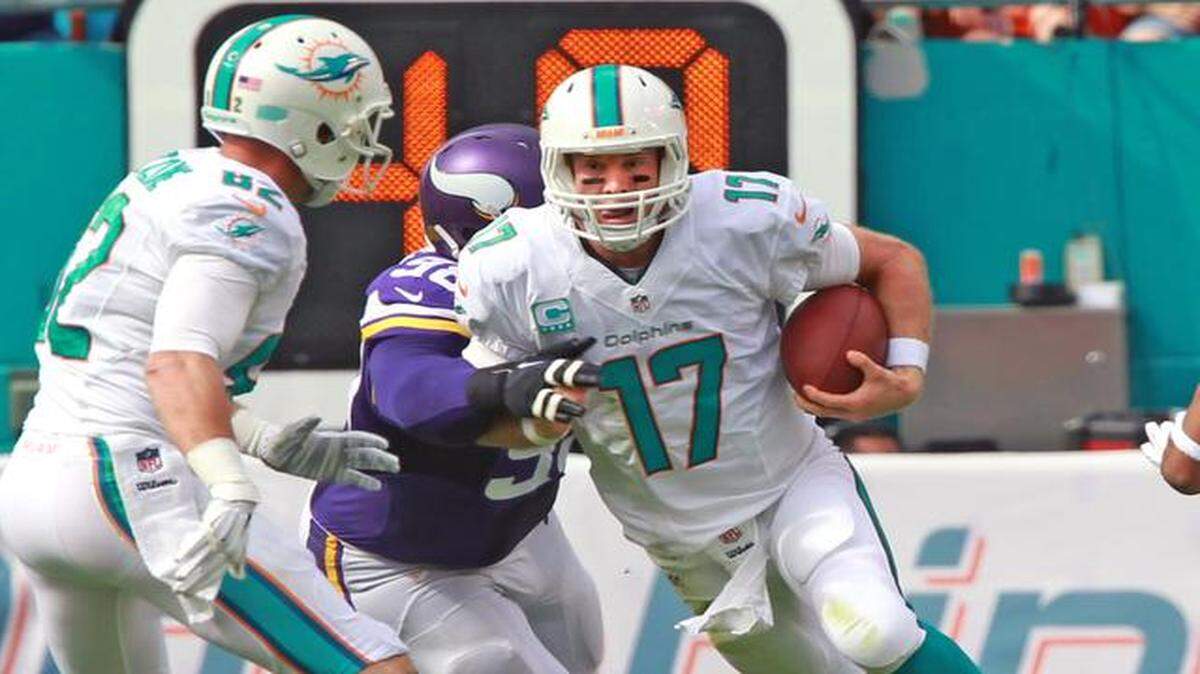 
Miami Dolphins quarterback Ryan Tannehill runs the ball as Minnesota Vikings defender Brandon Watts tackles him in the first quarter at Sun Life Stadium on Sunday, Dec. 21, 2014.
