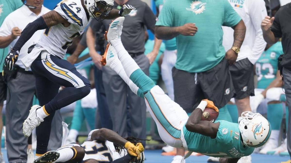 The Los Angeles Chargers' Trevor Williams, left, and Jahleel Addae bring down the Miami Dolphins' DeVante Parker after a first half reception attempt during their NFL football game at Stub Hub Center in Carson, CA on Sunday, September 17, 2017. (Photo by Kevin Sullivan, Orange County Register/SCNG)