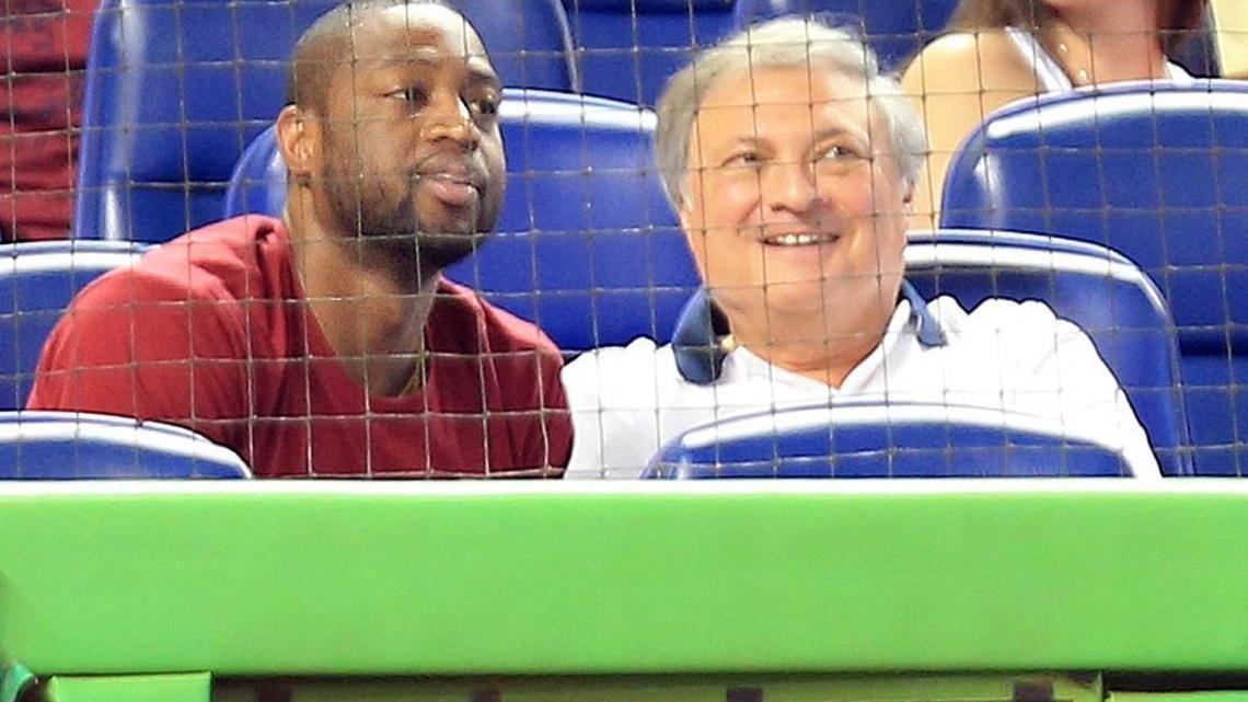 Then-Miami Heat guard Dwyane Wade sits next to Miami Marlins owner Jeff Loria, during the Miami Marlins vs Chicago Cubs game at Marlins Park in Miami on Wednesday, June 18 , 2014.