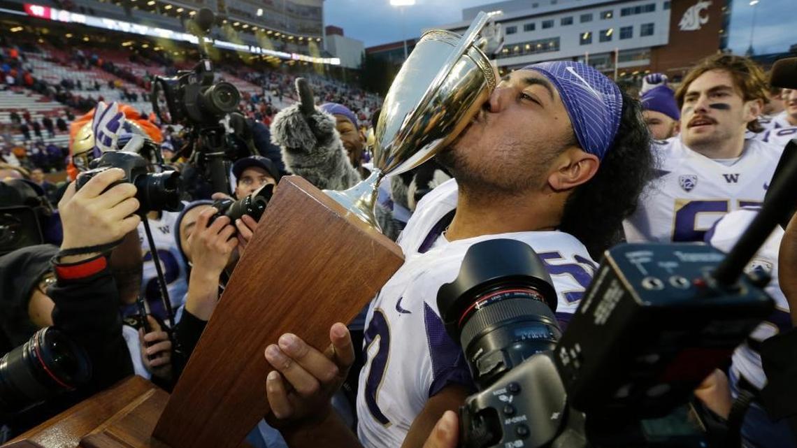 Washington defensive tackle Vita Vea kisses the Apple Cup trophy after Washington beat Washington State, 45-17, on Nov. 25. Vea is among possibilities for the Dolphins’ pick at No. 11.