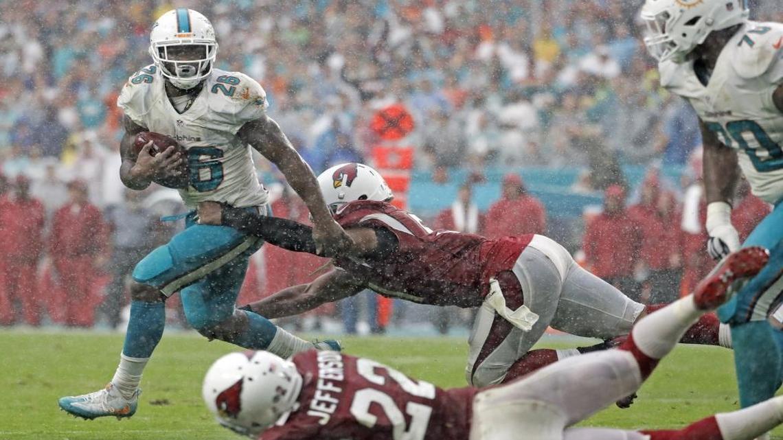 Miami Dolphins running back Damien Williams (26) runs in a down pour as the Miami Dolphins host Arizona Cardinals at Hard Rock Stadium on Sun., Dec. 11, 2016.