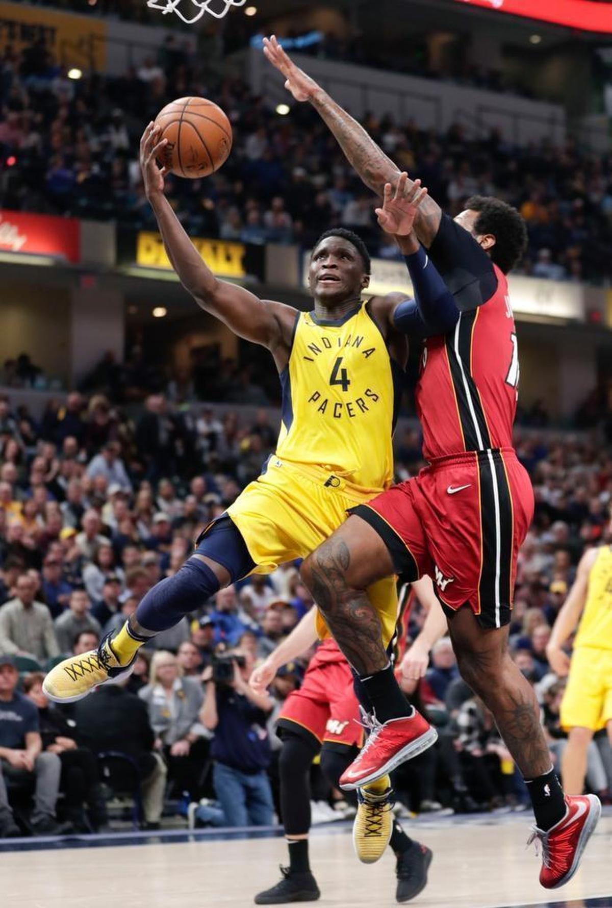 Indiana Pacers guard Victor Oladipo (4) shoots under Miami Heat forward James Johnson (16) during the second half of an NBA basketball game in Indianapolis, Sun., March 25, 2018. The Pacers defeated the Heat 113-107 in overtime.