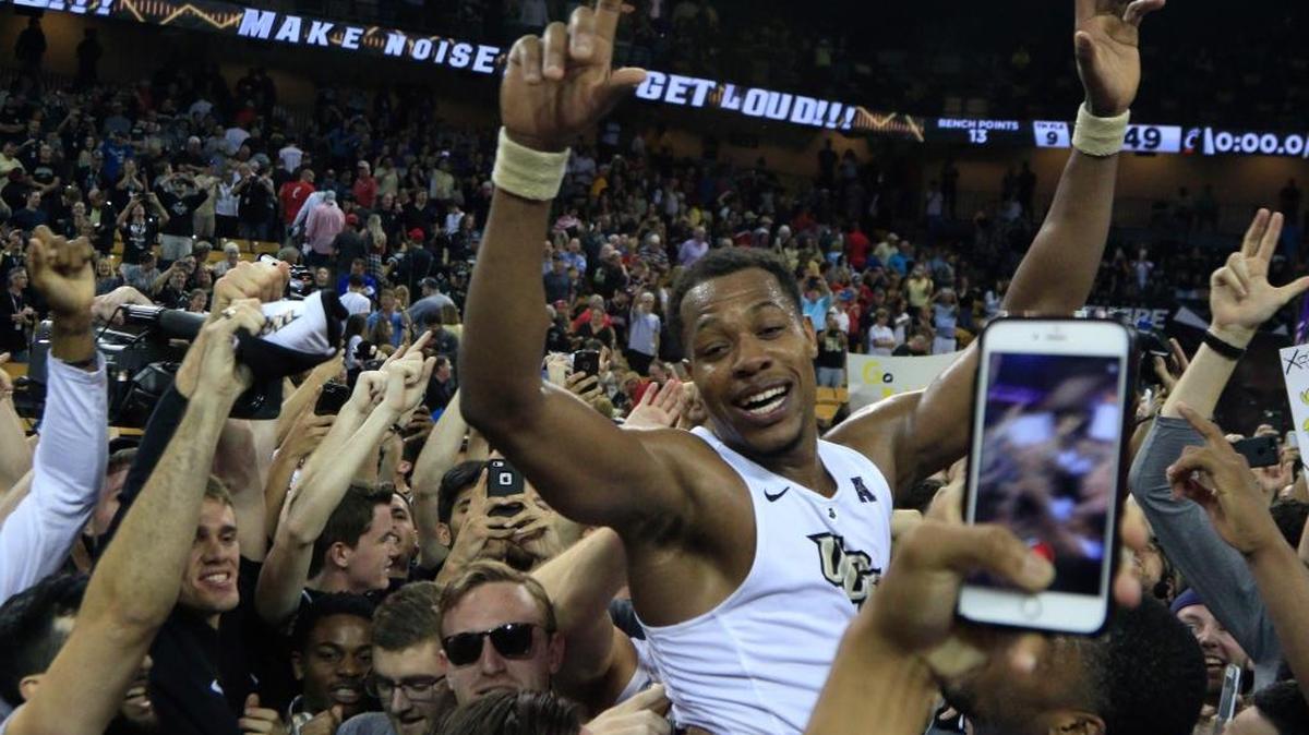 Central Florida guard Matt Williams, center, is lifted by teammates and students at center court after UCF defeated Cincinnati in an NCAA college basketball game in Orlando, Fla., on Sunday, Feb. 26, 2017. (AP Photo/Reinhold Matay)