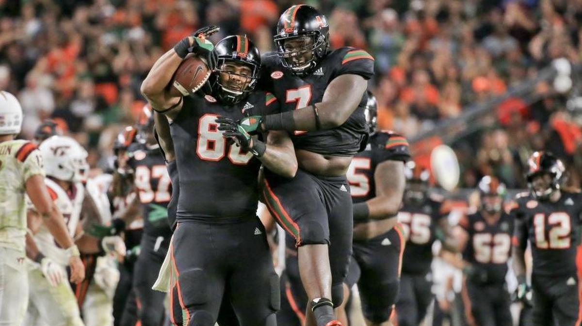 Miami Hurricanes defensive lineman RJ McIntosh (80) celebrates with teammate Kendrick Norton (7) after McIntosh recovered a fumble against the Virginia Tech Hokies at Hard Rock Stadium on Saturday, Nov. 4, 2017.