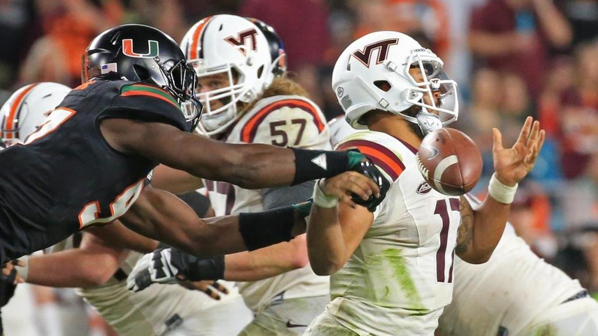 Miami Hurricanes defensive end Jonathan Garvin is shown knocking the ball loose from Virginia Tech Hokies quarterback Josh Jackson, who played last year at Hard Rock Stadium. The two teams meet again Saturday in Blacksburg, Virginia.