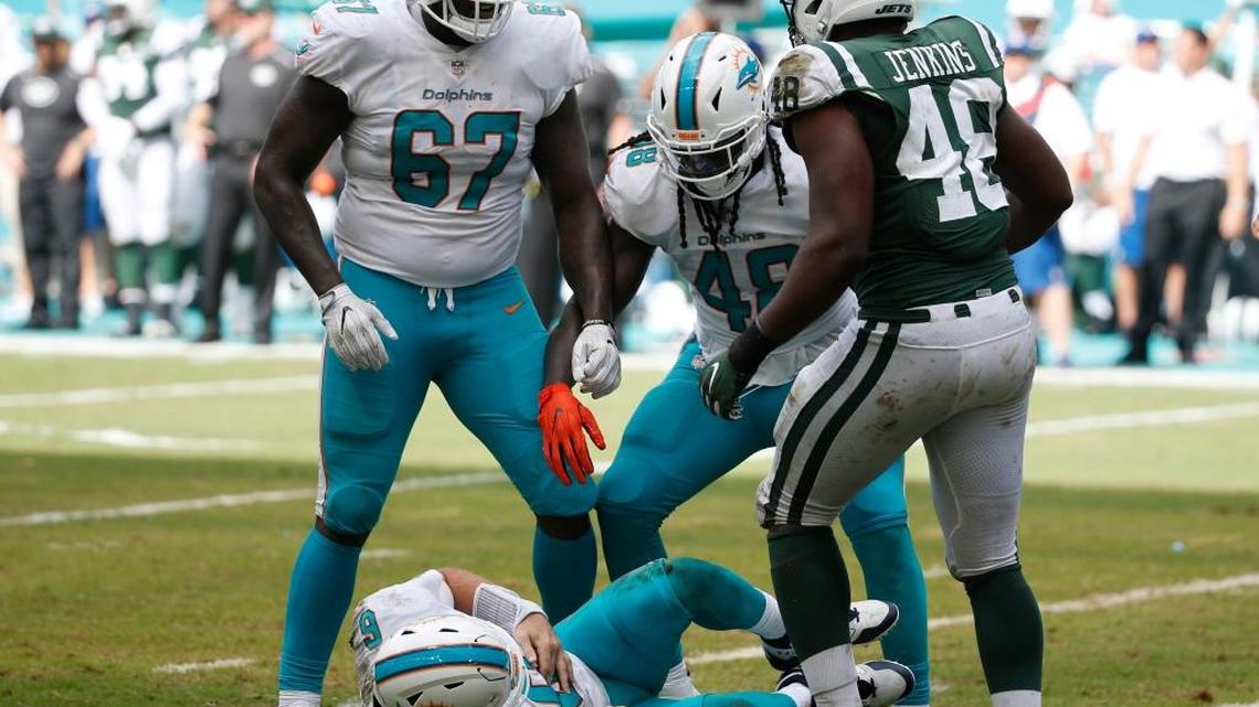 Miami Dolphins quarterback Jay Cutler (6) lies on the field after a hit by New York Jets outside linebacker Jordan Jenkins (48), during the first half of an NFL football game, Sunday, Oct. 22, 2017, in Miami Gardens, Fla. To the left is Miami Dolphins offensive tackle Laremy Tunsil (67) and Miami Dolphins tight end MarQueis Gray (48. Cutler was injured on the play. (AP Photo/Wilfredo Lee)