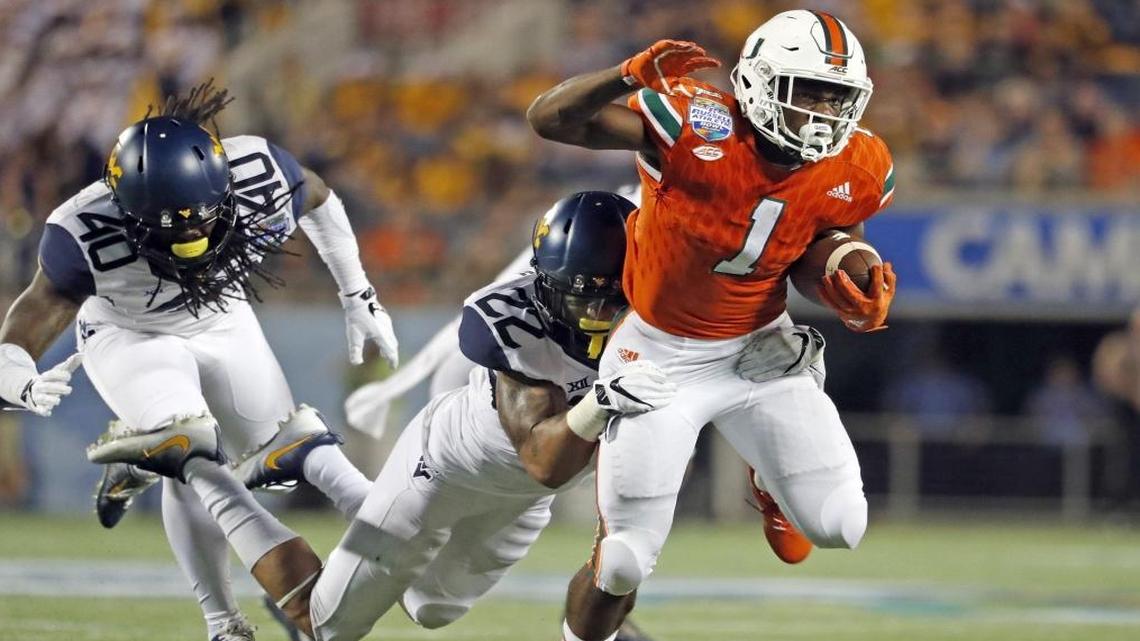 Miami Hurricanes running back Mark Walton (1) runs for a a first down in the fourth quarter as the University of Miami takes on the West Virginia Mountaineers at the Russell Athletic Bowl in Orlando Wed., Dec. 28, 2016.