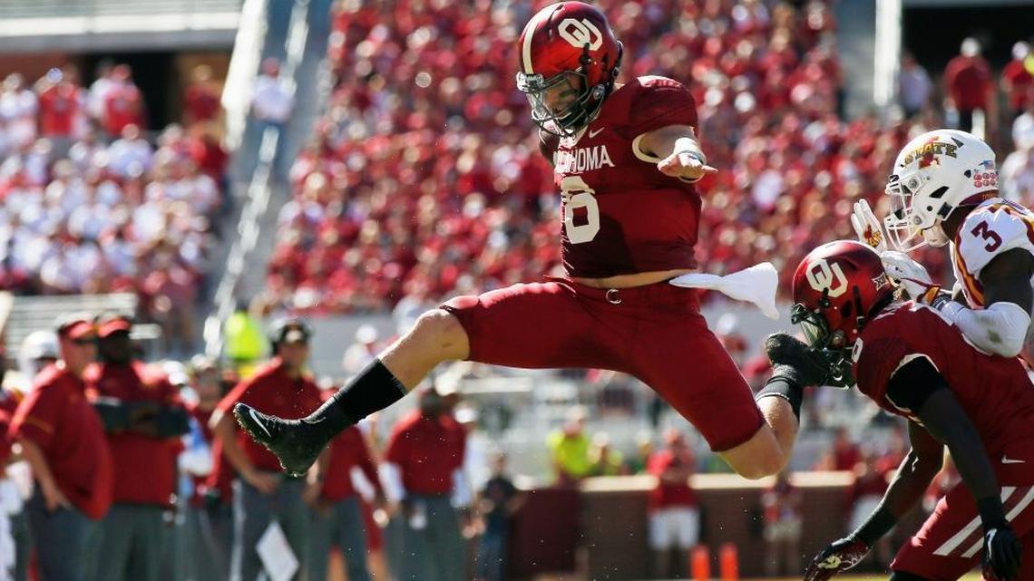Oklahoma quarterback Baker Mayfield (6) leaps over Iowa State defensive back De'Monte Ruth, bottom, in a game last season. The Dolphins have met once with Mayfield and will meet with him again. (AP Photo/Sue Ogrocki, File)