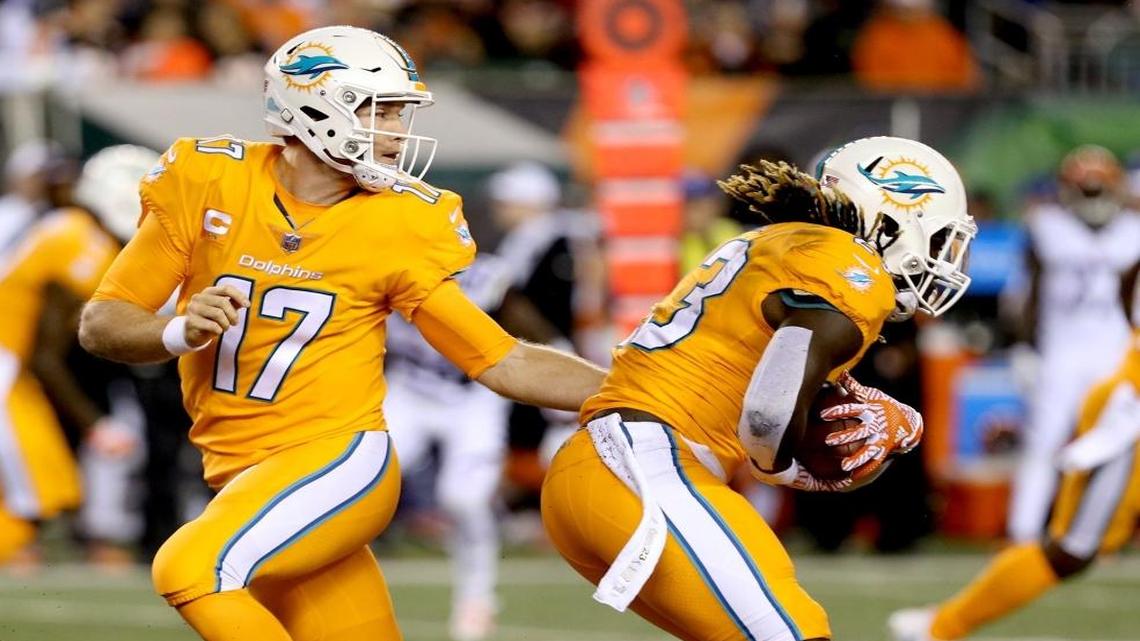 Miami Dolphins quarterback Ryan Tannehill hands the ball off to Jay Ajayi as they play the Cincinnati Bengals at Paul Brown Stadium in Cincinnati, Ohio, Thurs., Sept. 29, 2016.