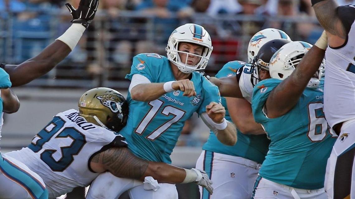 Miami Dolphins quarterback Ryan Tannehill is hit by Jacksonville Jaguars Tyson Alualu in the fourth quarter at EverBank Field in Jacksonville, Florida, Sept. 20, 2015.