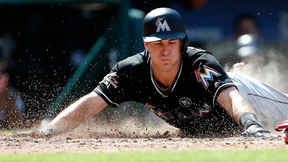 Miami Marlins catcher J.T. Realmuto dives into home plate with a with a two-run inside the park home run against the Philadelphia Phillies in an August game. J.T. Realmuto has requested a trade in the wake of the team’s latest payroll purge. (AP Photo/Rich Schultz, File)