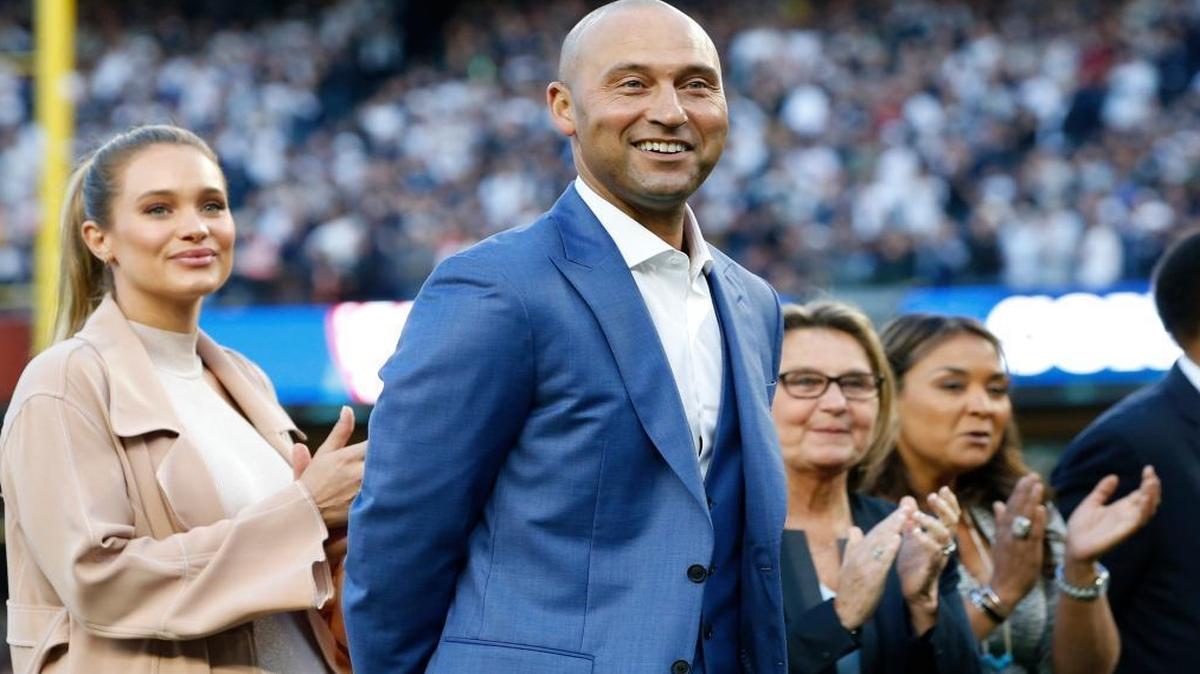 Retired New York Yankees shortstop Derek Jeter, center, his wife Hannah Jeter, left, his mother Dorothy and sister Sharlee are shown on the field during a pregame ceremony retiring his number 2 in Monument Park at Yankee Stadium in New York, Sun., May 14, 2017.