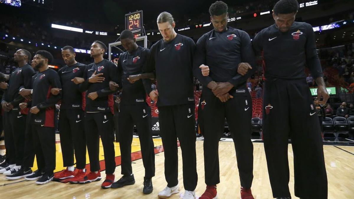 Members of the Miami Heat stand locking arms during the singing of the National Anthem before the start of an NBA preseason basketball game against the Charlotte Hornets, Monday, Oct. 9, 2017, in Miami. (AP Photo/Wilfredo Lee)