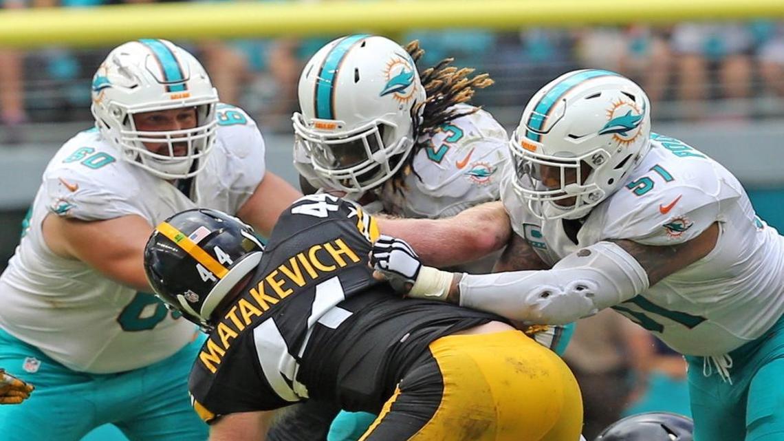 Miami Dolphins Kraig Urbik 60, Jay Ajayi 23, and Mike Pouncey 51, block Pittsburgh Steelers Tyler Matakevich, Oct. 16, 2016.