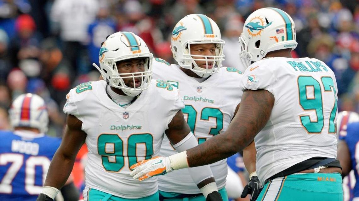 Miami Dolphins defensive end Charles Harris (90), defensive tackle Ndamukong Suh (93) and defensive tackle Jordan Phillips (97) celebrate a defensive stop during the first half of an NFL football game against the Buffalo Bills on Dec. 17. The Dolphins’ defensive line coach, Terrell Williams, is not being retained.