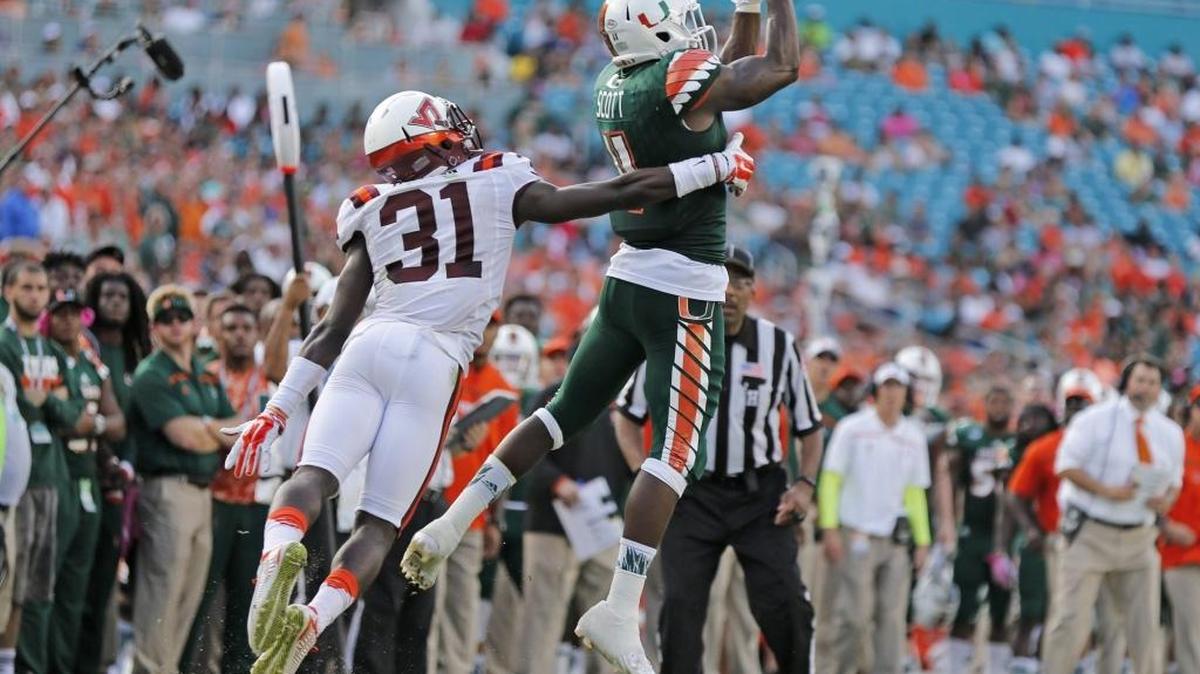 Miami Hurricanes wide receiver Rashawn Scott (11) as Virginia Tech Hokies cornerback Brandon Facyson (31) fails to make the stop on a first down reception in the second quarter as the University of Miami hosts Virginia Tech at Sun Life Stadium on Saturday at Sun Life Stadium.on Saturday, October 17, 2015.