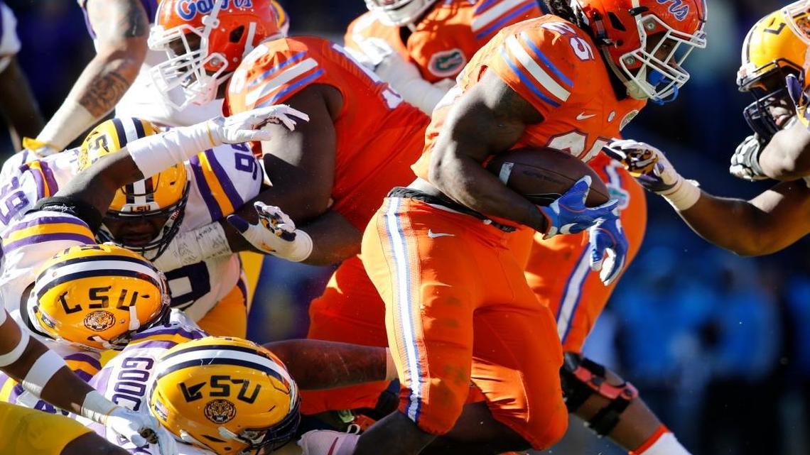 Florida running back Jordan Scarlett (25) carries past LSU defensive tackle Davon Godchaux and defensive tackle Greg Gilmore (99) in the second half an NCAA college football game in Baton Rouge, La., Sat., Nov. 19, 2016. Florida won 16-10.