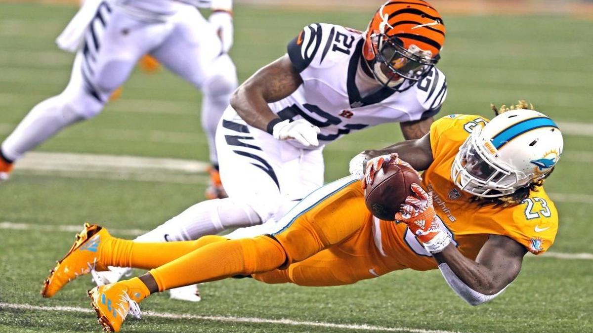 Miami Dolphins Jay Ajayi catches a first quarter pass as Cincinnati Bengals Darqueze Dennard defends at Paul Brown Stadium in Cincinnati, Ohio on Thurs., Sept. 29, 2016.