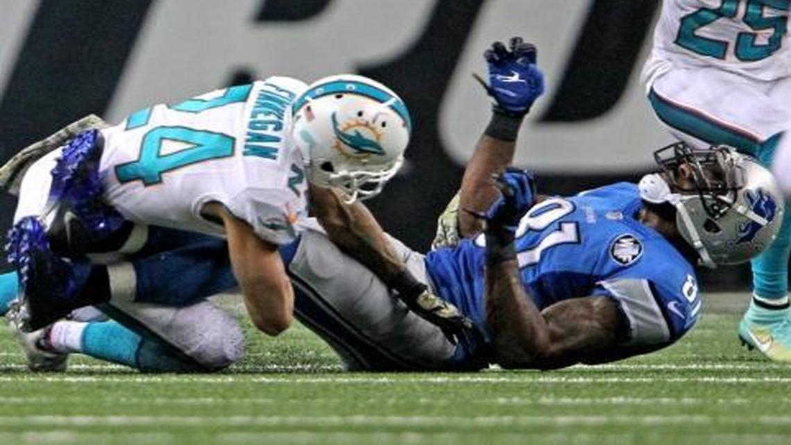Then-Miami Dolphins Cortland Finnegan hits Detroit Lions Calvin Johnson and defends the pass in the third quarter at Ford Field in Detroit, Michigan, Nov. 9, 2014.