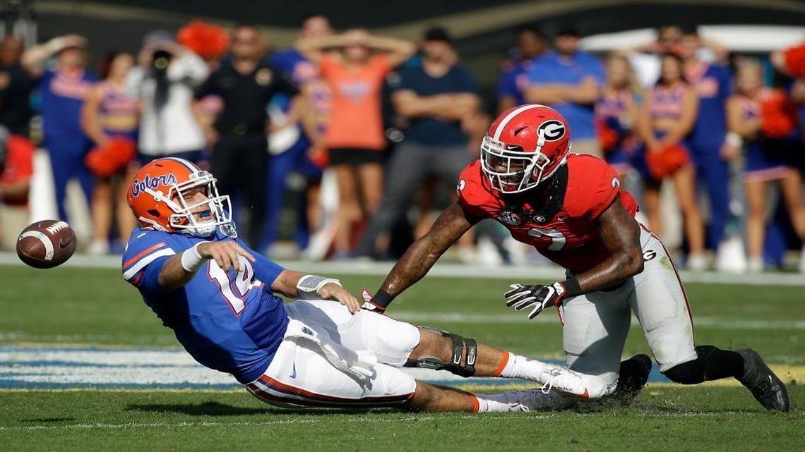 Florida quarterback Luke Del Rio, left, tries to pass the ball before being sacked by Georgia defensive back Maurice Smith during the first half of an NCAA college football game, Saturday, Oct. 29, 2016, in Jacksonville, Fla.