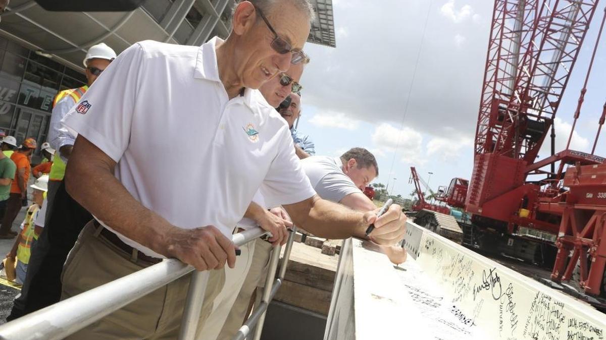 Miami Dolphins owner Stephen Ross signs the last piece of steel before it is erected for the stadium canopy on Friday, July 29, 2016 in Miami Gardens. During the topping out ceremony, Ross said the half-billion-dollar renovation project is right on schedule.
