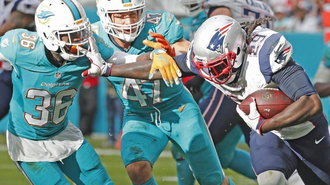 Dolphins middle linebacker Kiko Alonso (47) and cornerback Tony Lippett (36) attempt to stop New England Patriots running back LeGarrette Blount in Miami’s final regular-season game at Hard Rock Stadium this past Sunday.