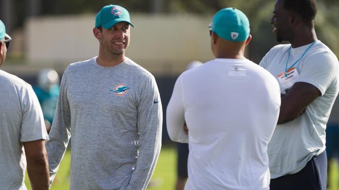 Dolphins coach Adam Gase talks to Golden State Warriors forward Draymond Green during training camp at the Miami Dolphins training facility in Davie on July 30, 2017.