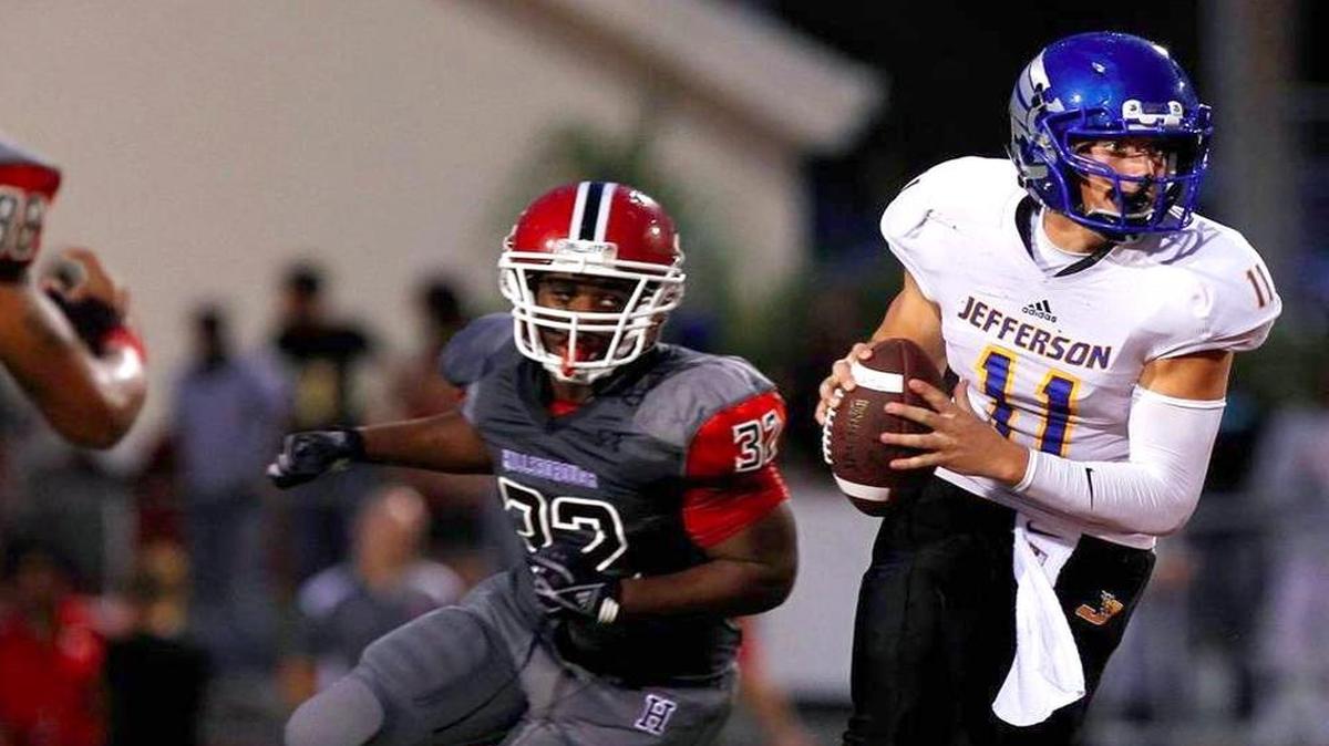 Tampa Jefferson quarterback Cade Weldon looks for an open receiver while Hillsborough linebacker Armand Chalk (32) purses him during the first quarter Fri., Sept. 5, 2014 at Hillsborough High School.