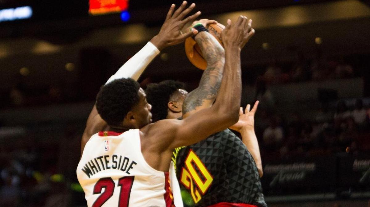 The Miami Heat's Hassan Whiteside (21) blocks a shot by the Atlanta Hawks' John Collins (20) during the first quarter of Tuesday’s win. Whiteside played well two days after being fined by the team. (Daniel A. Varela/Miami Herald/TNS)