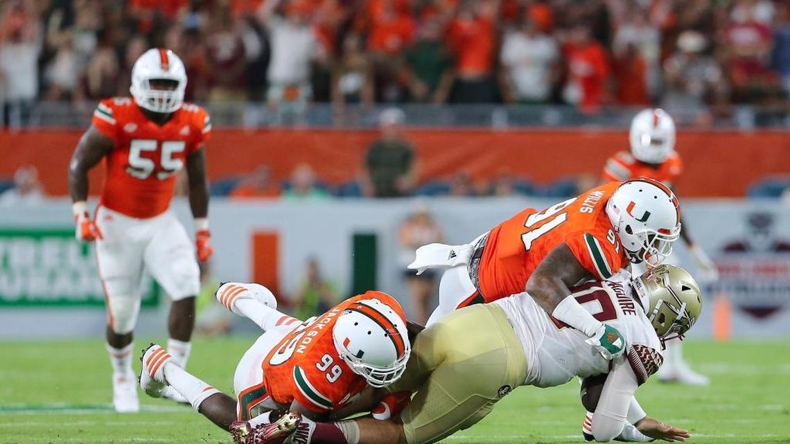 University of Miami Hurricanes linebacker Gerald Willis ,91, and teammate defensive linemen Joe Jackson , 99, sacks Florida State Seminoles quarterbacks Sean Maguire in the secopnd quarter of an NCAA college football game at Hard Rock Stadium on Saturday October 8, 2016, in Miami Gardens.