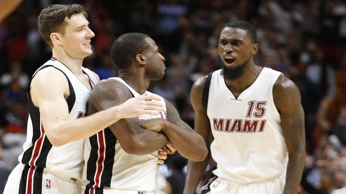 Miami Heat guard Goran Dragic, left, and forward Okaro White (15) congratulate guard Dion Waiters, center, after Waiters scored a 3-pointer with 0.6 seconds left in an NBA basketball game against the Golden State Warriors, Monday, Jan. 23, 2017, in Miami. Waiters had 33 points as the Heat defeated the Warriors 105-102.