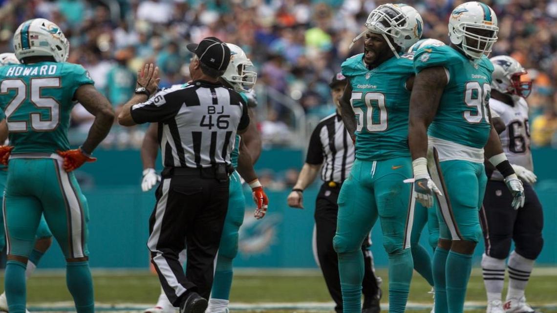 Miami Dolphins defensive end Andre Branch (50) and cornerback Xavier Howard (25) argue a penalty call at Hard Rock Stadium in Miami Gardens, Florida, Jan. 1, 2017.