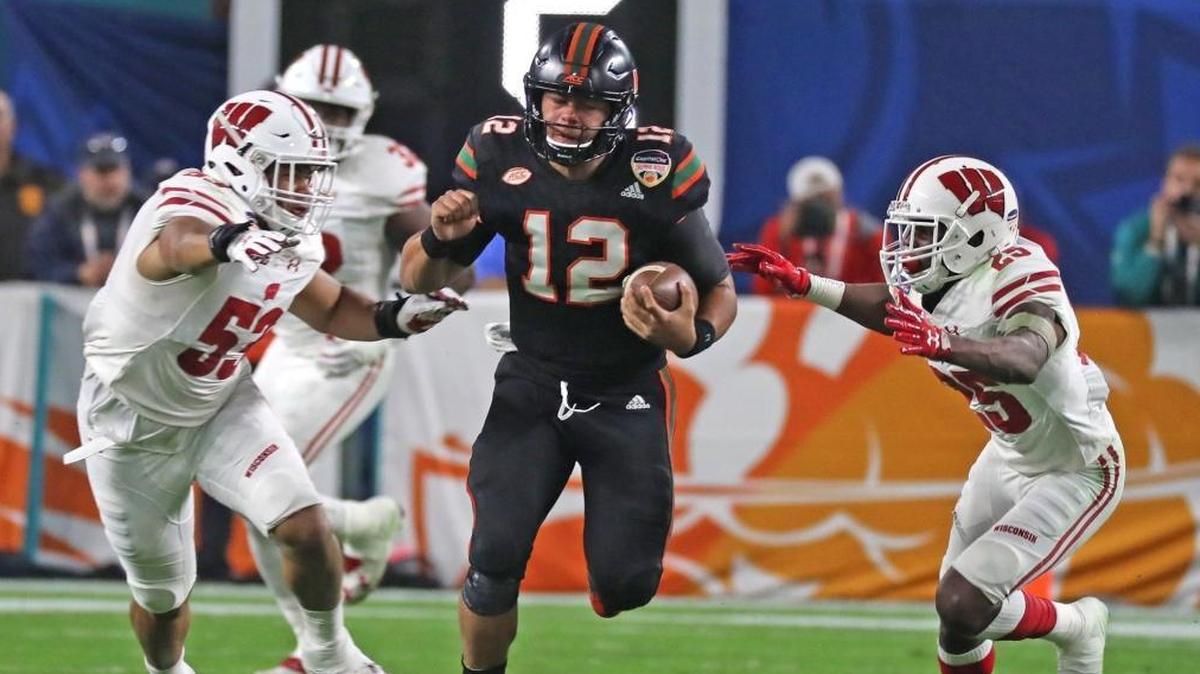 Miami Hurricanes quarterback Malik Rosier (12) runs between Wisconsin Badgers T.J. Edwards (53) and Derrick Tindrl (25) in last season’s Orange Bowl. Rosier is trying to hold off N’Kosi Perry and others in the battle for UM’s QB job.