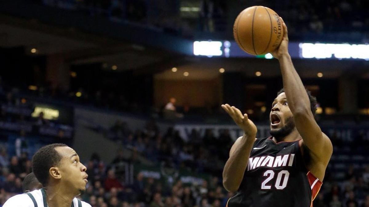 Miami Heat forward Justise Winslow passes the ball over Milwaukee Bucks center John Henson in Wednesday’s Heat win. Winslow his improved his perimeter shooting. (AP Photo/Aaron Gash)