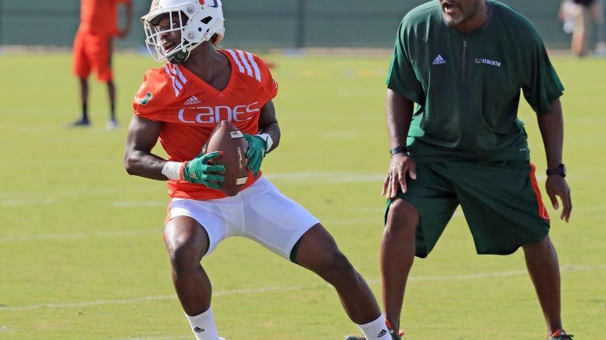 Wide receivers coach Ron Dugans with Jeff Thomas (4) as the University of Miami opens fall football camp at Greentree Field on Tuesday, August 1, 2017.