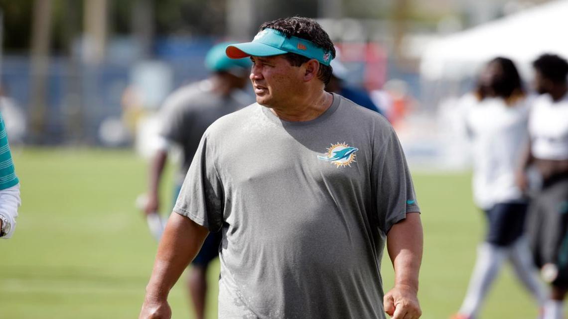 Miami Dolphins offensive coordinator Clyde Christensen walks off the field, Monday, Aug. 15, 2016, after practice at NFL football training camp in Davie, Fla.